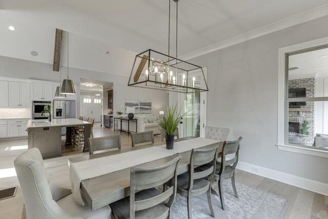 4781 Falling Brook Dr, Flowery Branch, GA 30542 - dining space featuring light wood-style floors, plenty of natural light, baseboards, and a chandelier