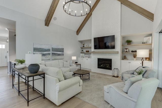 4781 Falling Brook Dr, Flowery Branch, GA 30542 - living area featuring a chandelier, light wood finished floors, beamed ceiling, high vaulted ceiling, and a glass covered fireplace
