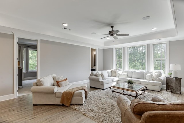 4781 Falling Brook Dr, Flowery Branch, GA 30542 - living room featuring a raised ceiling, healthy amount of natural light, ceiling fan, light wood-style floors, and recessed lighting