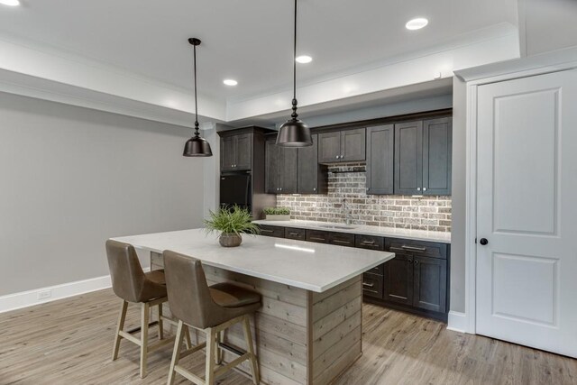 4781 Falling Brook Dr, Flowery Branch, GA 30542 - kitchen with a sink, light wood-style floors, decorative backsplash, a kitchen breakfast bar, and recessed lighting