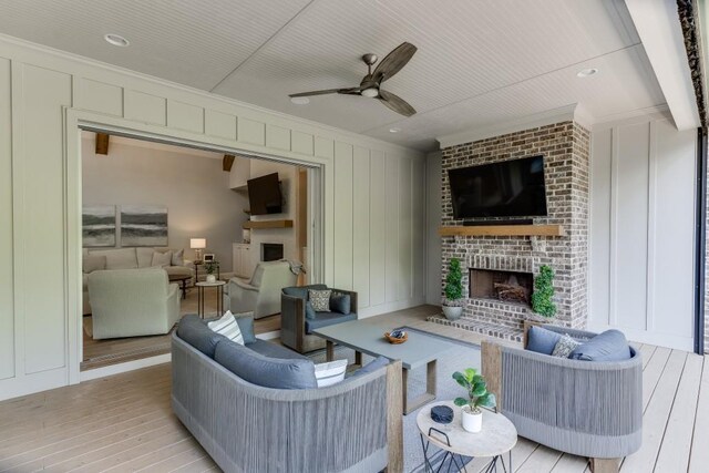 4781 Falling Brook Dr, Flowery Branch, GA 30542 - living room with a fireplace, crown molding, light wood-style floors, ceiling fan, and a decorative wall
