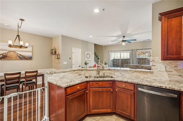 kitchen featuring dishwasher, sink, hanging light fixtures, backsplash, and ceiling fan with notable chandelier