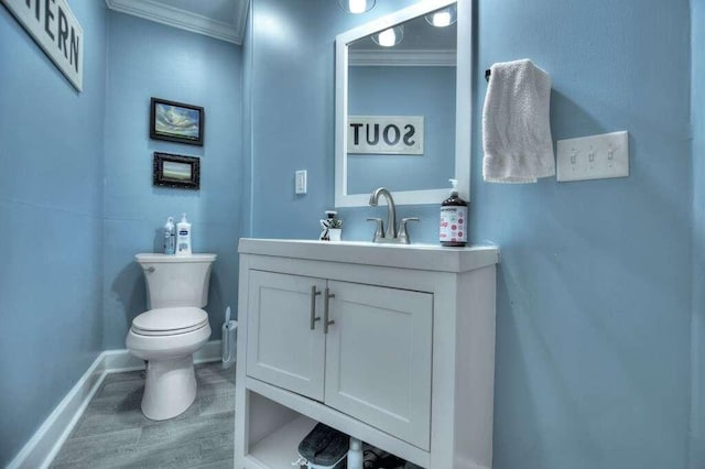 bathroom featuring ornamental molding, hardwood / wood-style flooring, vanity, and toilet