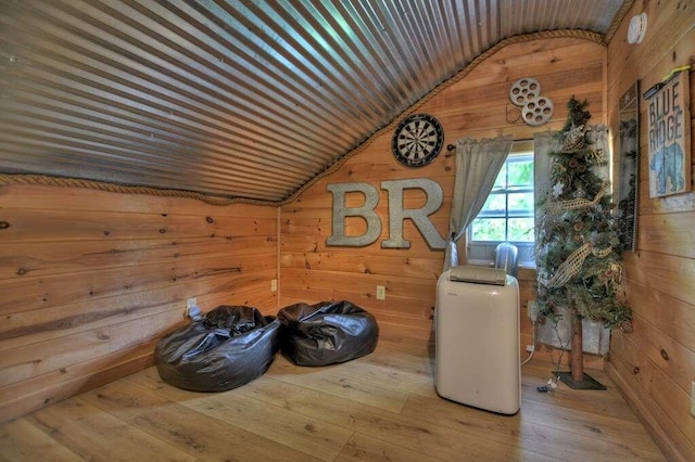 bonus room featuring wooden walls, vaulted ceiling, and hardwood / wood-style floors