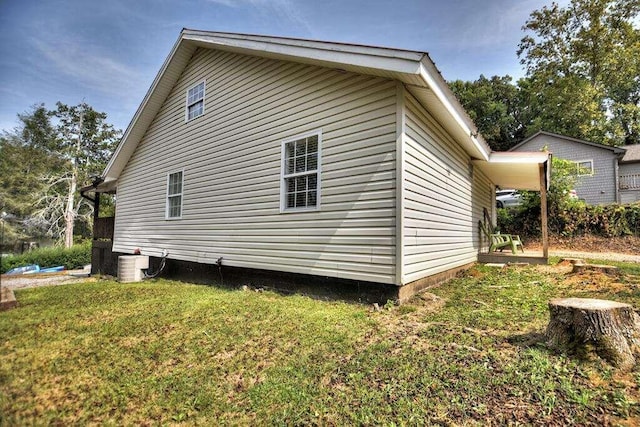 view of side of home featuring a lawn and central AC