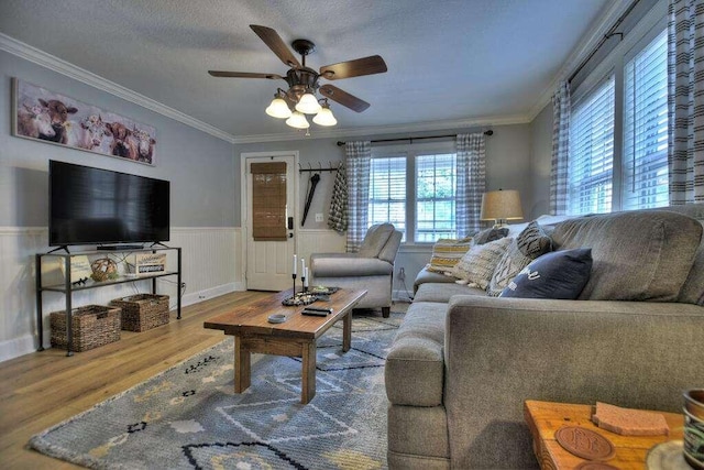 living room featuring ornamental molding, hardwood / wood-style flooring, plenty of natural light, and ceiling fan