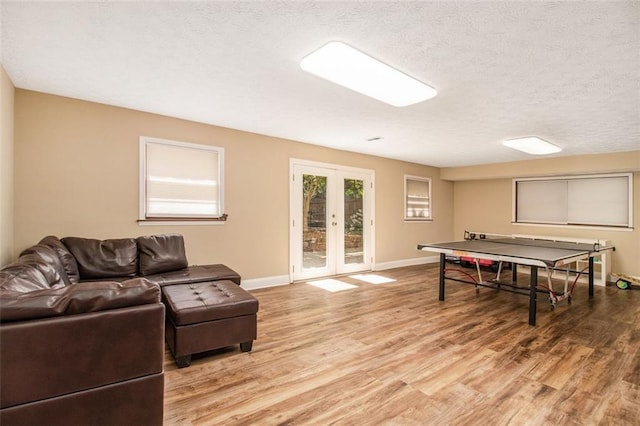 1935 Northbrooke Ln, Dunwoody, GA 30338 - playroom featuring light wood finished floors, french doors, baseboards, and a textured ceiling