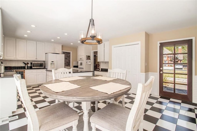 1935 Northbrooke Ln, Dunwoody, GA 30338 - dining room with light flooring, a chandelier, wainscoting, and recessed lighting