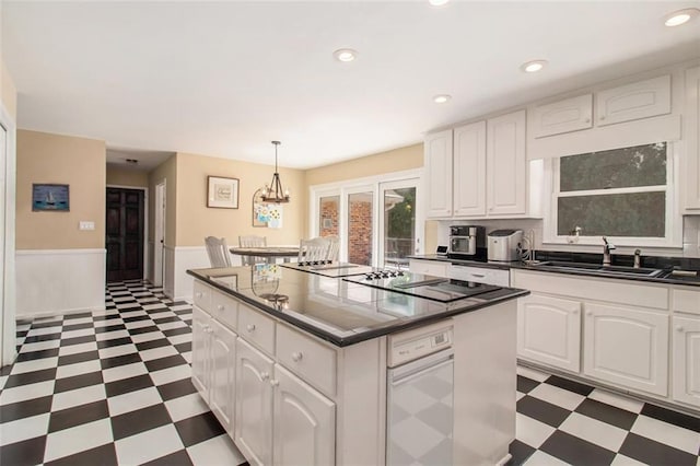 1935 Northbrooke Ln, Dunwoody, GA 30338 - kitchen with dark flooring, a sink, dark countertops, black electric stovetop, and a wainscoted wall