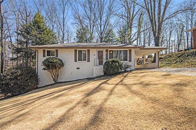 ranch-style home featuring brick siding, an attached carport, a front lawn, crawl space, and driveway