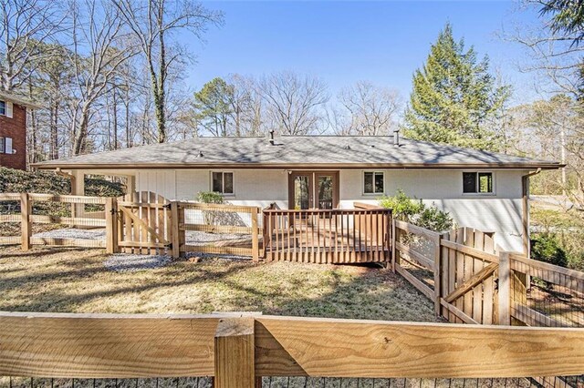 rear view of property with a deck, a gate, and fence