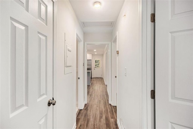 hall with attic access and dark wood-style flooring