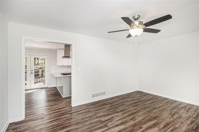 interior space with dark wood finished floors, baseboards, visible vents, and ceiling fan