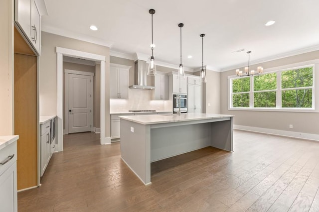 4525 Aiden Way, Cumming, GA 30041 - kitchen featuring wall chimney range hood, stainless steel appliances, a chandelier, ornamental molding, and decorative backsplash