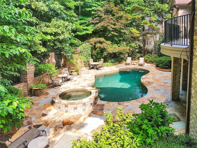 view of swimming pool featuring an in ground hot tub and a patio area