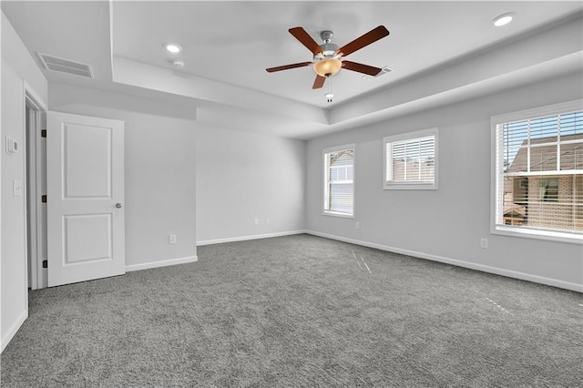 spare room with carpet floors, ceiling fan, and a tray ceiling