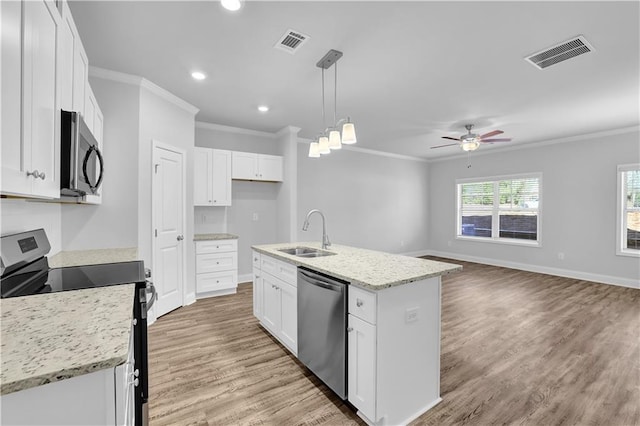 kitchen with stainless steel appliances, white cabinetry, and a center island with sink