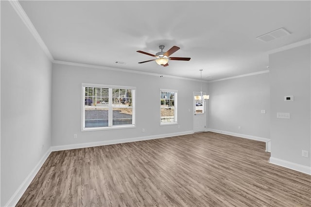 spare room featuring hardwood / wood-style flooring, ceiling fan with notable chandelier, and ornamental molding