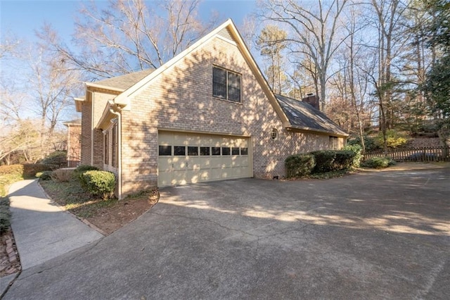 4116 River Cliff Chase SE, Marietta, GA 30067 - view of home's exterior with a chimney, fence, an attached garage, driveway, and brick siding