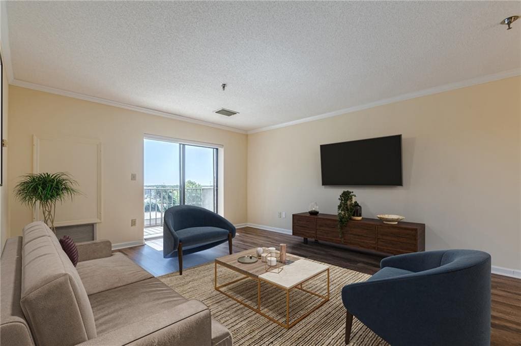 living room with hardwood / wood-style flooring, a textured ceiling, and ornamental molding