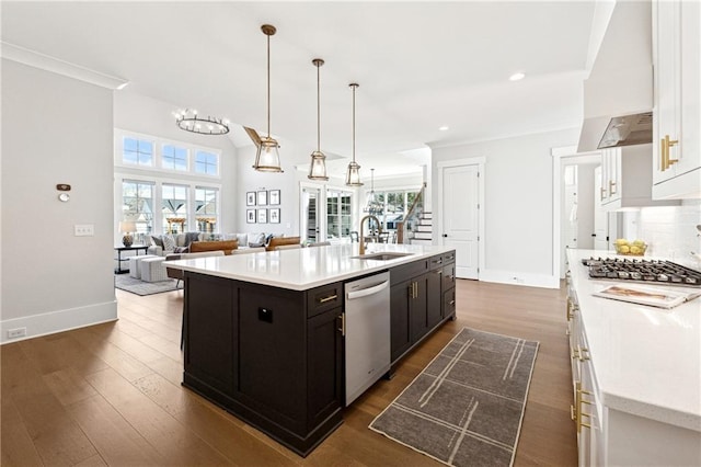 kitchen featuring pendant lighting, sink, white cabinets, an island with sink, and stainless steel appliances