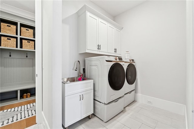 laundry area with sink, light tile patterned floors, cabinets, and separate washer and dryer