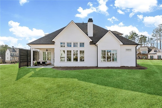 back of house with a patio area, a yard, and ceiling fan