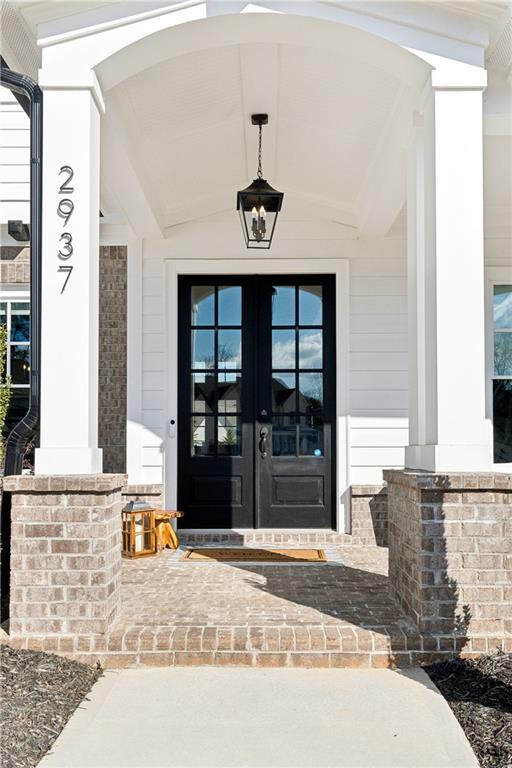 property entrance featuring a porch and french doors