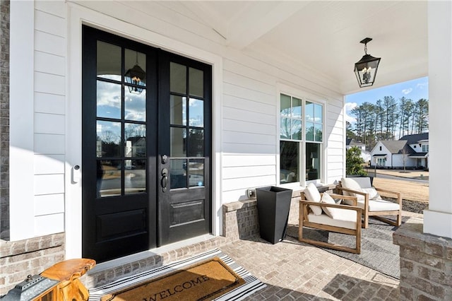 doorway to property with covered porch and french doors