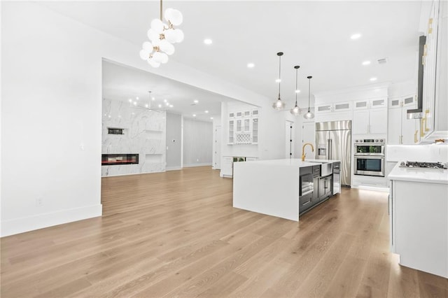 5175 Cascade Rd, Atlanta, GA 30331 - kitchen with stainless steel appliances, a premium fireplace, light countertops, a chandelier, and white cabinetry