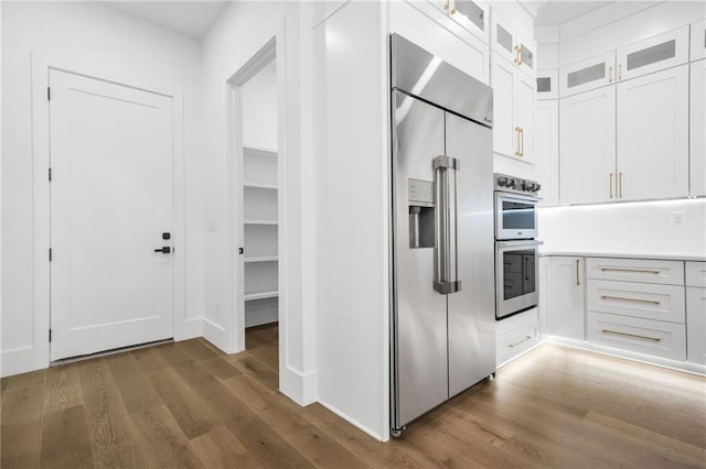 5175 Cascade Rd, Atlanta, GA 30331 - kitchen with appliances with stainless steel finishes, wood finished floors, white cabinets, glass insert cabinets, and light countertops