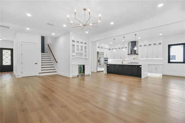 5175 Cascade Rd, Atlanta, GA 30331 - unfurnished living room featuring beverage cooler, stairway, recessed lighting, baseboards, and light wood finished floors
