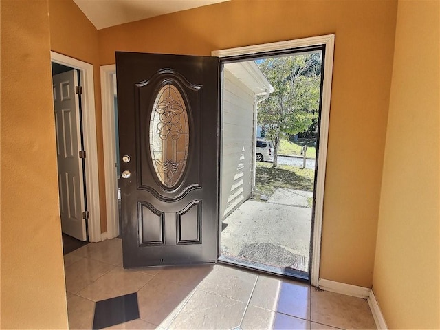 foyer with lofted ceiling and light tile patterned flooring