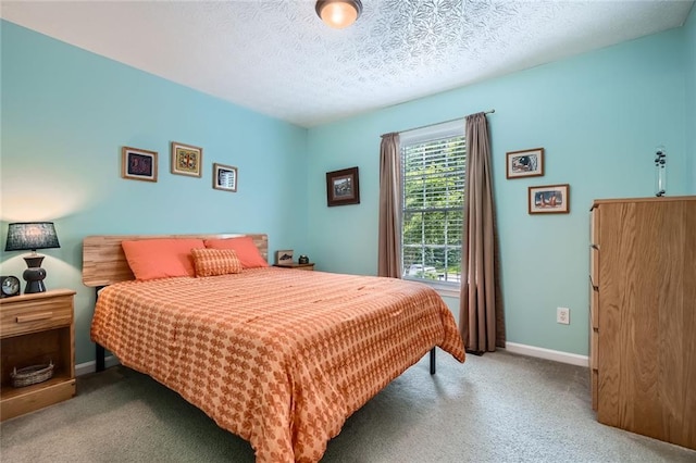 bedroom featuring carpet, baseboards, and a textured ceiling