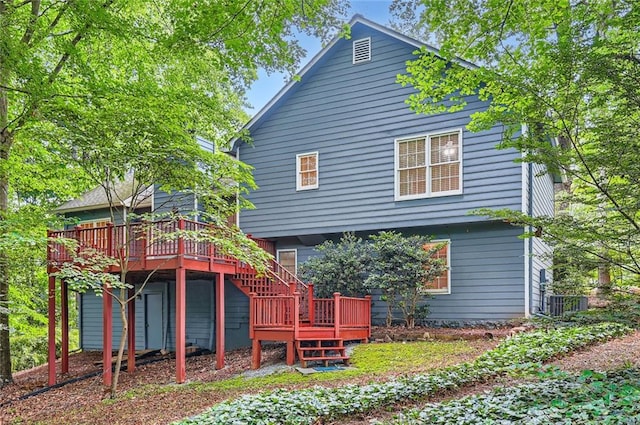 rear view of house with a deck, stairs, and cooling unit