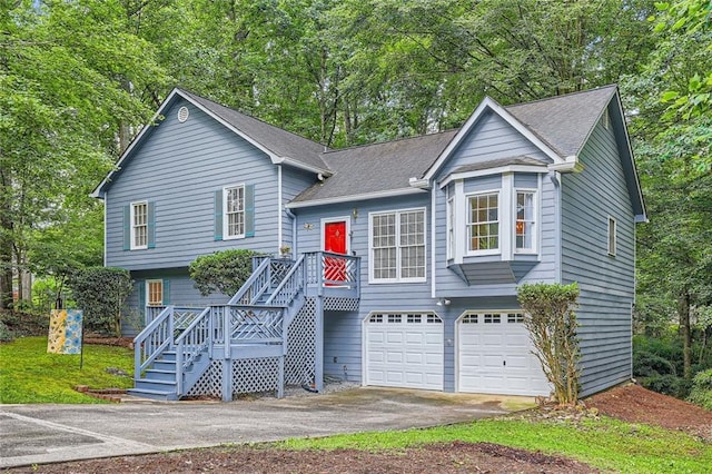 view of front of home with driveway, an attached garage, and roof with shingles
