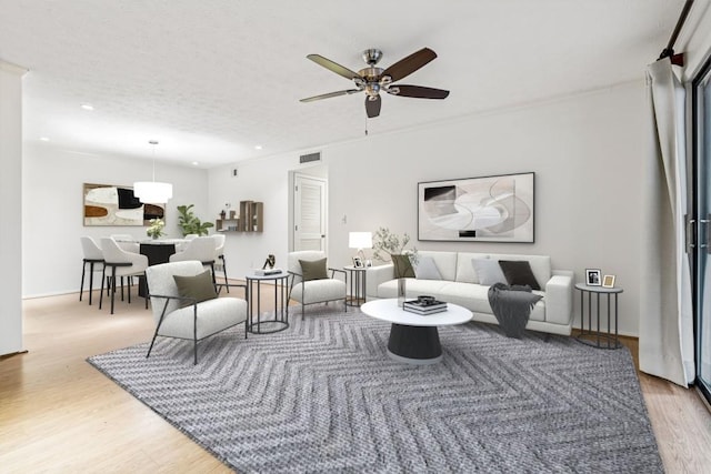 living room featuring ceiling fan and light wood-type flooring