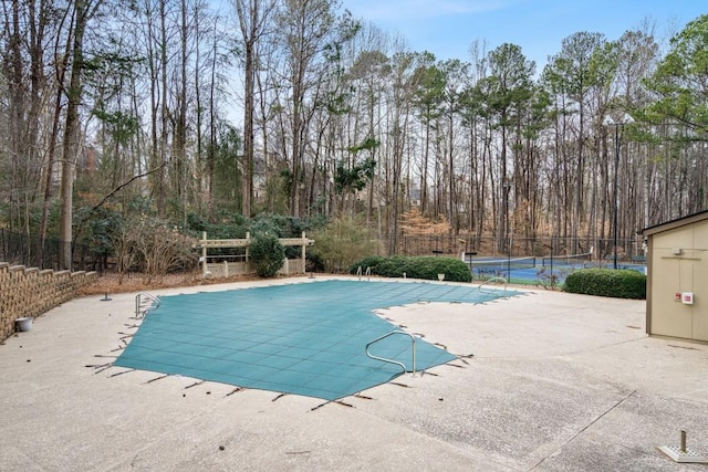 view of swimming pool with tennis court