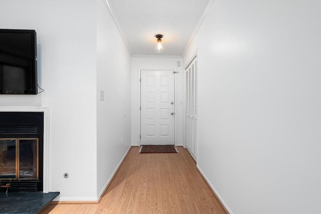 hallway featuring wood-type flooring and ornamental molding