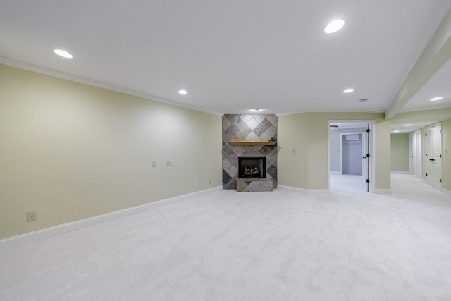 unfurnished living room with light carpet, ornamental molding, and a tiled fireplace