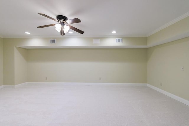 basement with light colored carpet, ceiling fan, and ornamental molding