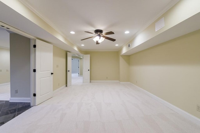 carpeted spare room featuring ceiling fan and crown molding