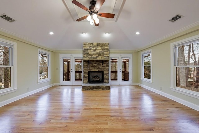 unfurnished living room with french doors, light wood-type flooring, a fireplace, ornamental molding, and lofted ceiling