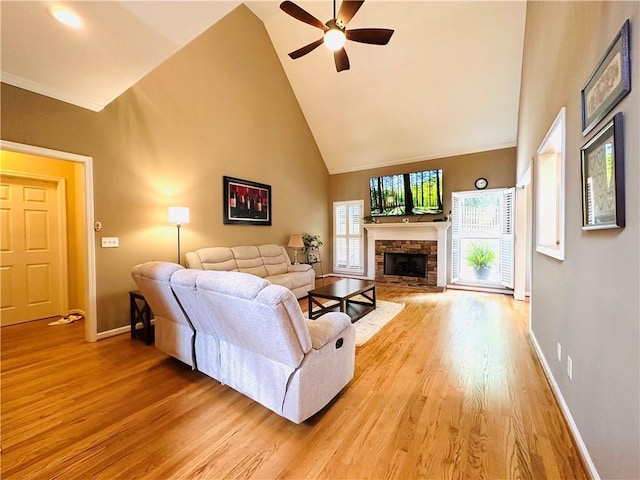 1739 Praters Pt, Dacula, GA 30019 - living room featuring high vaulted ceiling, light wood-style flooring, ceiling fan, a stone fireplace, and baseboards