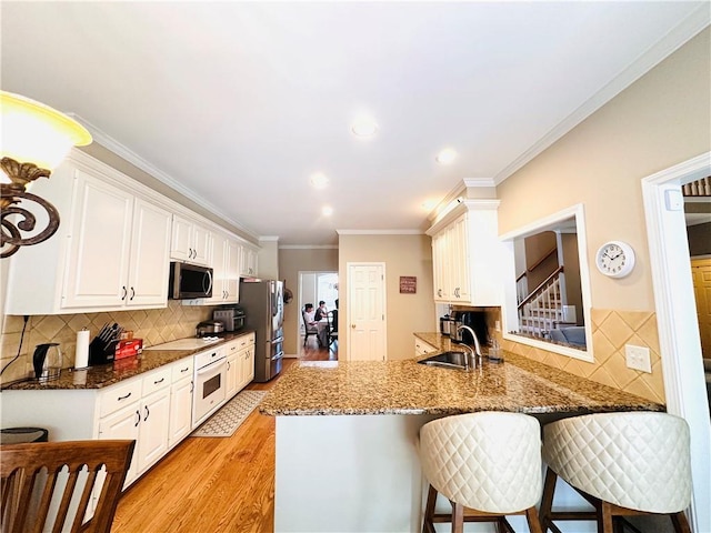 1739 Praters Pt, Dacula, GA 30019 - kitchen with stainless steel appliances, a sink, decorative backsplash, light wood-style floors, and white cabinets