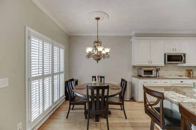 1739 Praters Pt, Dacula, GA 30019 - dining room with a chandelier, healthy amount of natural light, ornamental molding, and light wood-style flooring
