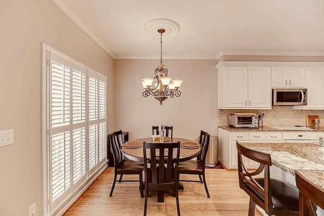 1739 Praters Pt, Dacula, GA 30019 - dining space featuring a chandelier, ornamental molding, light wood-type flooring, and baseboards