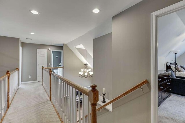 1739 Praters Pt, Dacula, GA 30019 - hall featuring an upstairs landing, light colored carpet, recessed lighting, baseboards, and a chandelier