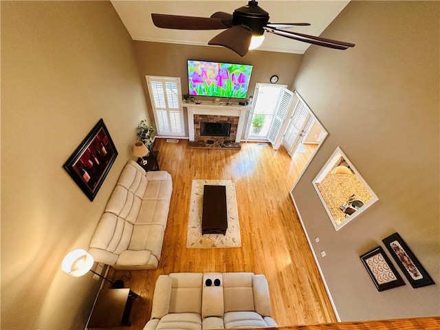 1739 Praters Pt, Dacula, GA 30019 - living area with ceiling fan, wood finished floors, a fireplace, a towering ceiling, and ornamental molding