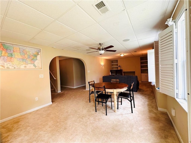 1739 Praters Pt, Dacula, GA 30019 - carpeted dining room featuring arched walkways, ceiling fan, a paneled ceiling, stairway, and baseboards